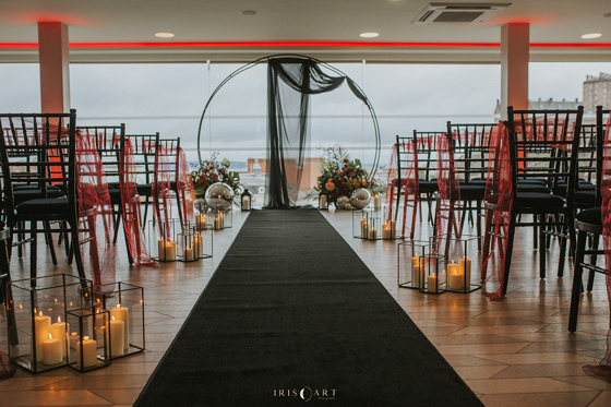Moody red and black ceremony set up with candles and altar hoop